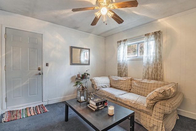 living area featuring baseboards, carpet, and a ceiling fan