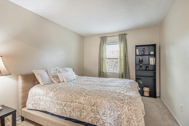 bedroom featuring a textured ceiling, baseboards, and light carpet