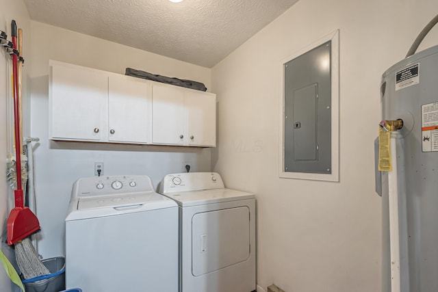 washroom featuring electric panel, cabinet space, water heater, a textured ceiling, and independent washer and dryer