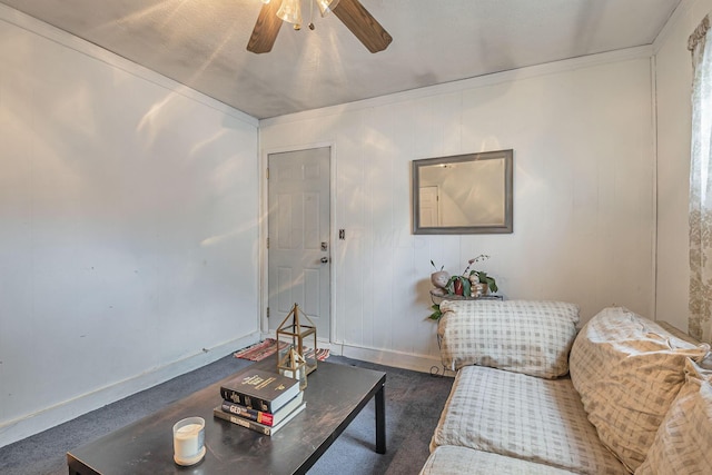 living area with baseboards and ceiling fan