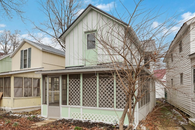 rear view of house featuring a sunroom and metal roof