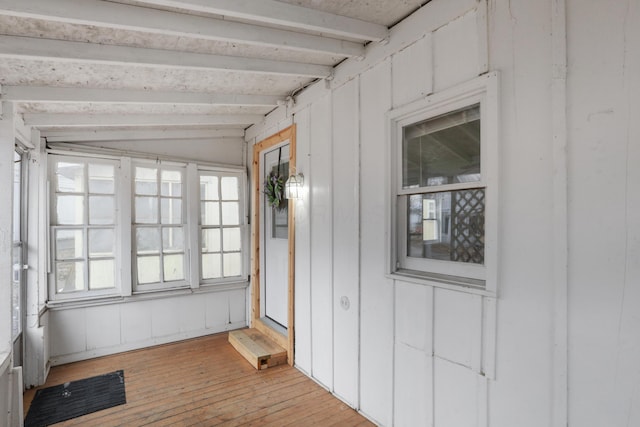 unfurnished sunroom featuring beamed ceiling