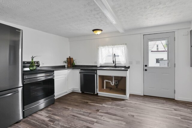 71 3rd St, Lancaster, OH 43130 - kitchen featuring stainless steel appliances, a textured ceiling, dark wood-type flooring, dark countertops, and beam ceiling