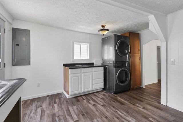 71 3rd St, Lancaster, OH 43130 - washroom with electric panel, stacked washer / drying machine, dark wood-type flooring, and a textured ceiling