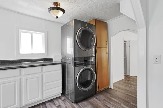 71 3rd St, Lancaster, OH 43130 - laundry room featuring estacked washer and dryer, cabinet space, dark wood-style flooring, and a textured ceiling