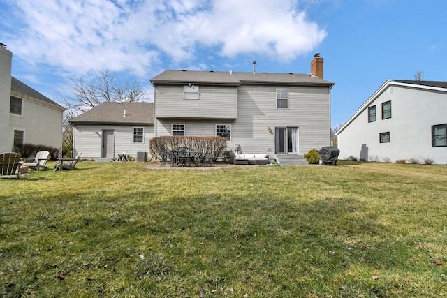 back of property featuring a patio, a lawn, a chimney, and entry steps