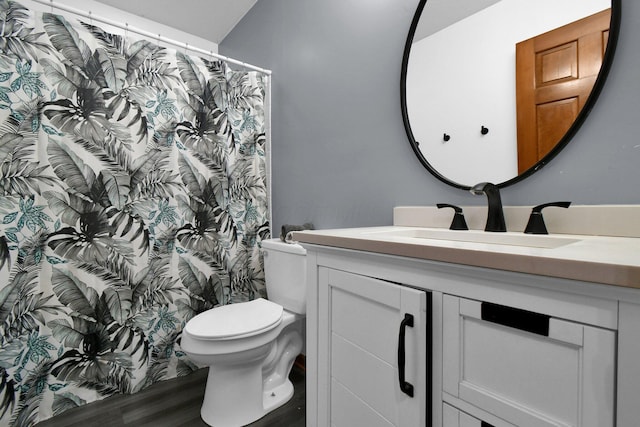 full bath featuring vanity, a shower with shower curtain, toilet, and wood finished floors