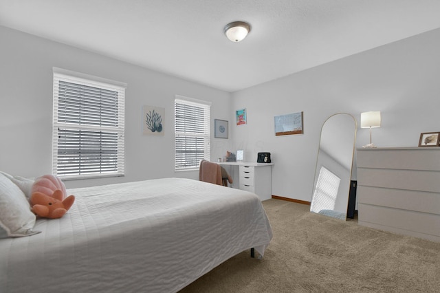 bedroom with light colored carpet and baseboards