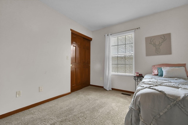 bedroom featuring baseboards, visible vents, and light carpet