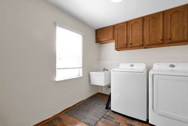 laundry area with independent washer and dryer, a sink, cabinet space, baseboards, and dark wood-style flooring