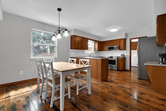 dining space featuring washer / dryer, baseboards, and dark wood-style flooring