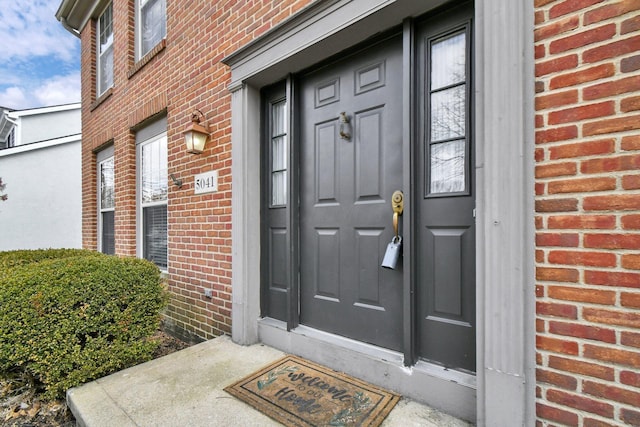 property entrance featuring brick siding