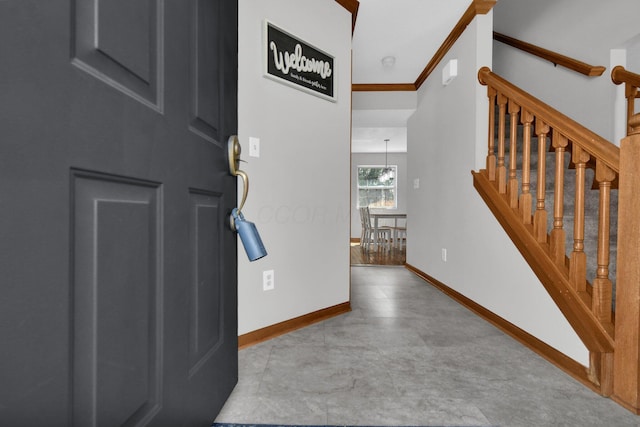 foyer with stairway, baseboards, and ornamental molding