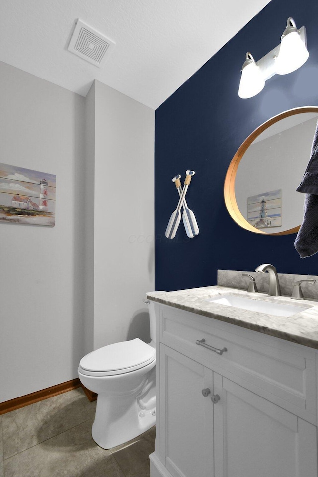 bathroom featuring vanity, baseboards, visible vents, tile patterned flooring, and toilet