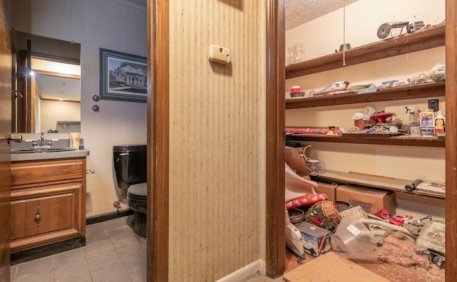 interior space featuring toilet, a textured ceiling, vanity, and tile patterned floors