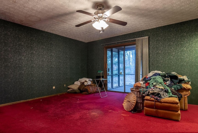 playroom with carpet floors, wallpapered walls, a ceiling fan, and a textured ceiling