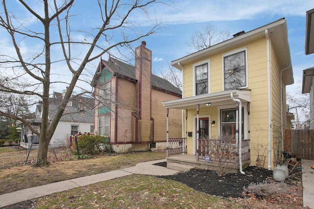 view of front of property featuring a porch and fence