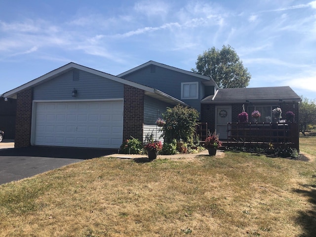 view of front facade featuring a garage, brick siding, a front lawn, and aphalt driveway