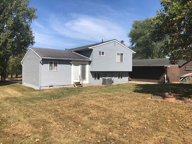 rear view of property featuring a yard and central air condition unit