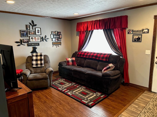 living area featuring a textured ceiling, ornamental molding, and wood finished floors