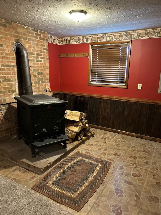 details with wooden walls, a wood stove, wainscoting, and a textured ceiling