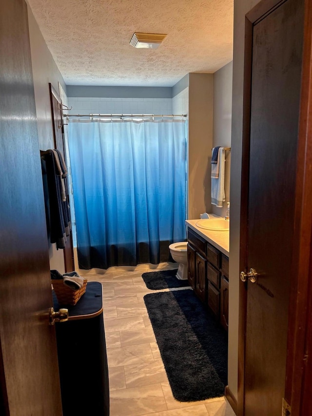 full bathroom with toilet, a shower with curtain, a textured ceiling, and vanity