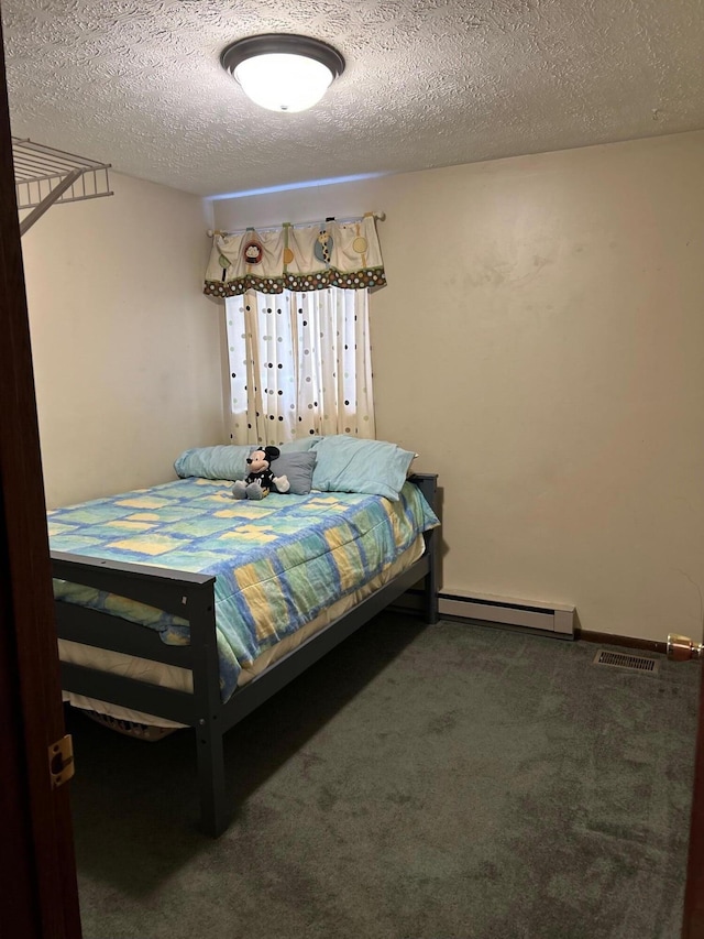 bedroom with a textured ceiling, carpet floors, a baseboard radiator, and visible vents