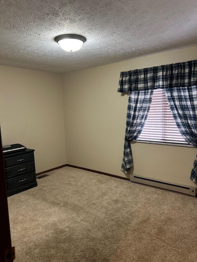 carpeted spare room featuring baseboards, visible vents, a baseboard heating unit, and a textured ceiling