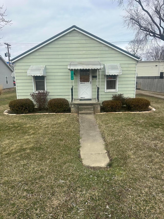 bungalow with a front yard and fence