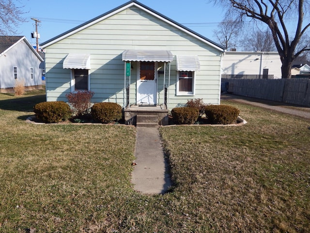 bungalow featuring a front yard and fence