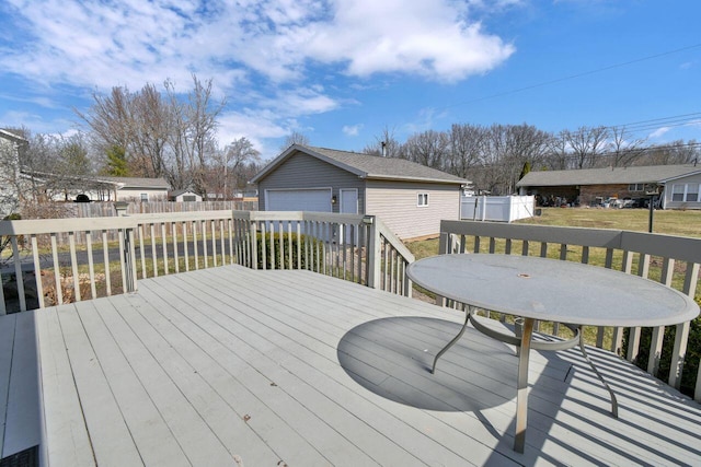 wooden deck with a yard, a residential view, an outbuilding, and fence