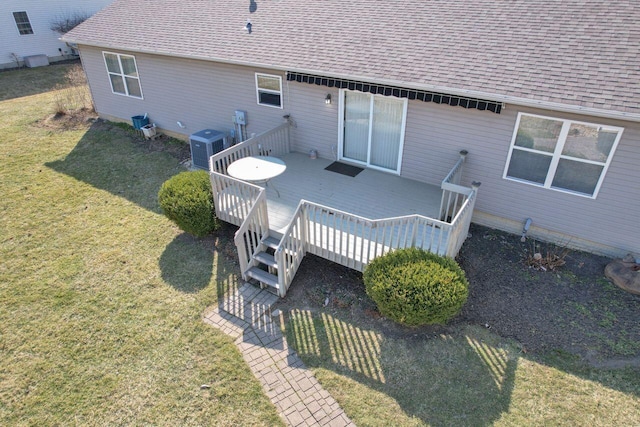 back of house with a deck, central AC unit, a lawn, and roof with shingles