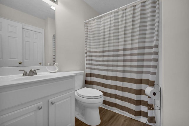 bathroom featuring vanity, a shower with curtain, wood finished floors, a textured ceiling, and toilet