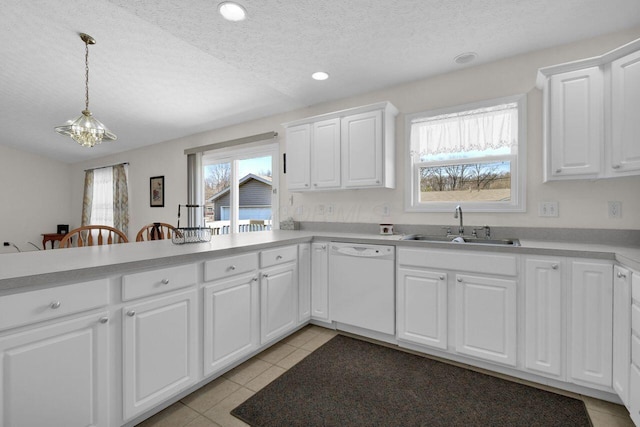 kitchen featuring dishwasher, light countertops, a wealth of natural light, and a sink