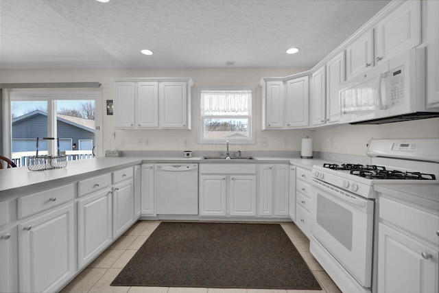 kitchen featuring a sink, white appliances, and white cabinets