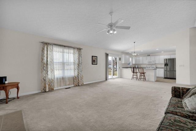 living room with light carpet, lofted ceiling, ceiling fan with notable chandelier, a textured ceiling, and baseboards