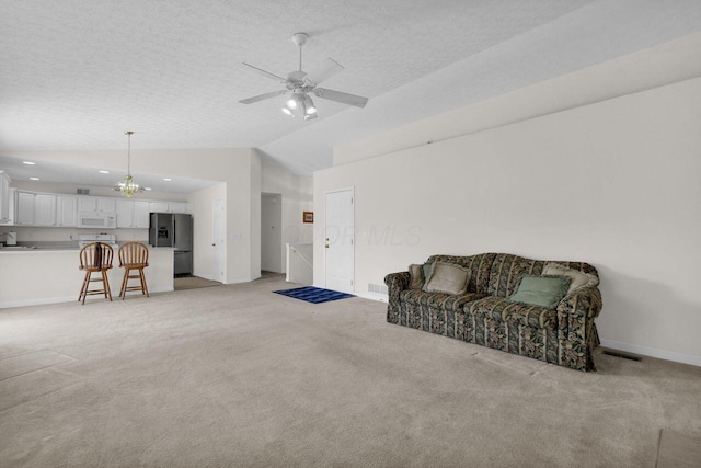 sitting room with light carpet, visible vents, a textured ceiling, and vaulted ceiling