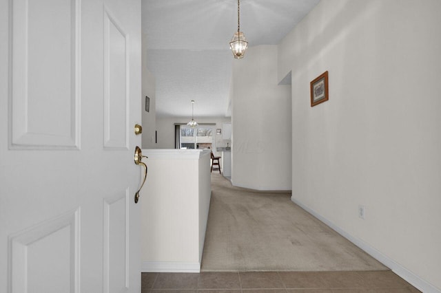 interior space featuring tile patterned floors, baseboards, and a chandelier