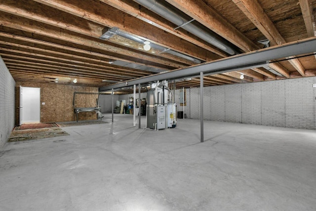 unfinished basement featuring gas water heater, heating unit, and brick wall