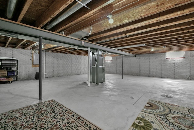 unfinished basement featuring electric panel and brick wall