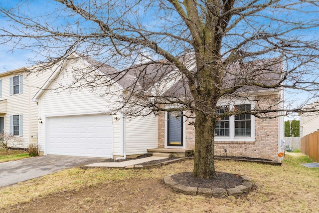 view of front of house with a garage, brick siding, aphalt driveway, fence, and a front yard