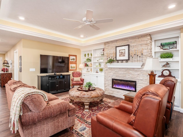 living room featuring built in shelves, ceiling fan, recessed lighting, a fireplace, and wood finished floors