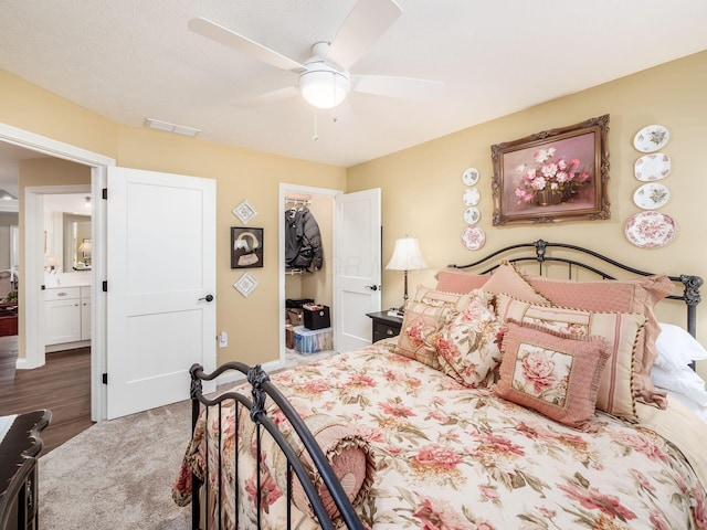 bedroom with a spacious closet, visible vents, and ceiling fan