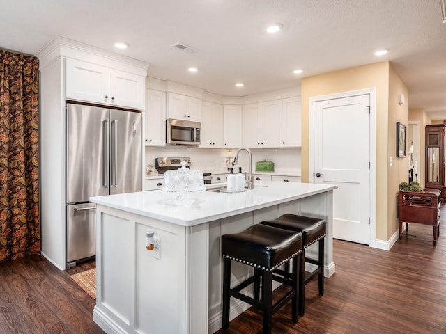 kitchen with visible vents, dark wood-style flooring, light countertops, white cabinets, and appliances with stainless steel finishes