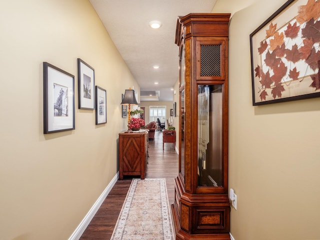 hallway with recessed lighting, baseboards, and dark wood-style flooring