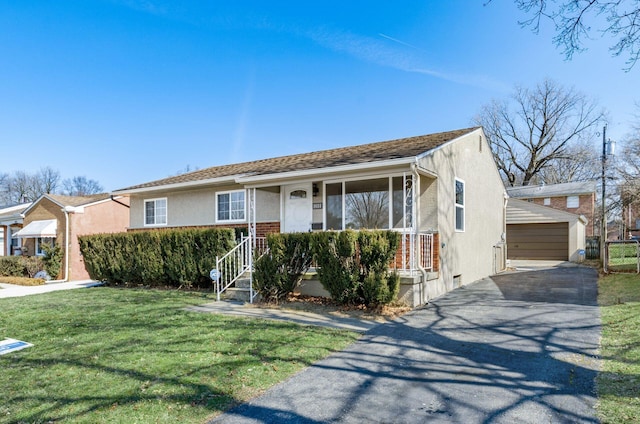 view of front of home featuring an outbuilding, a front yard, covered porch, stucco siding, and brick siding