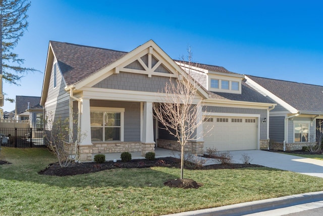 craftsman inspired home featuring stone siding, an attached garage, a front yard, and roof with shingles