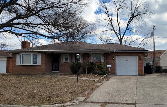 ranch-style house with concrete driveway, brick siding, a chimney, and an attached garage