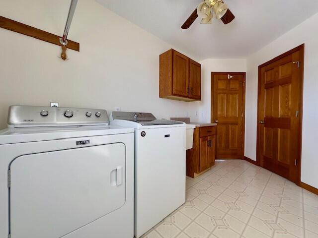 laundry room featuring baseboards, a ceiling fan, cabinet space, and washer and dryer