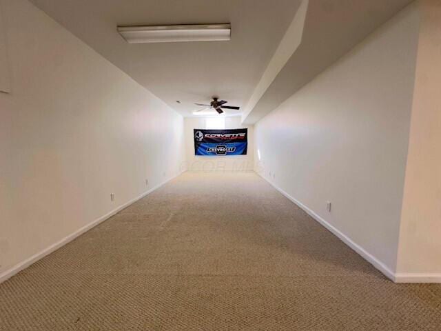 hallway featuring carpet flooring and baseboards